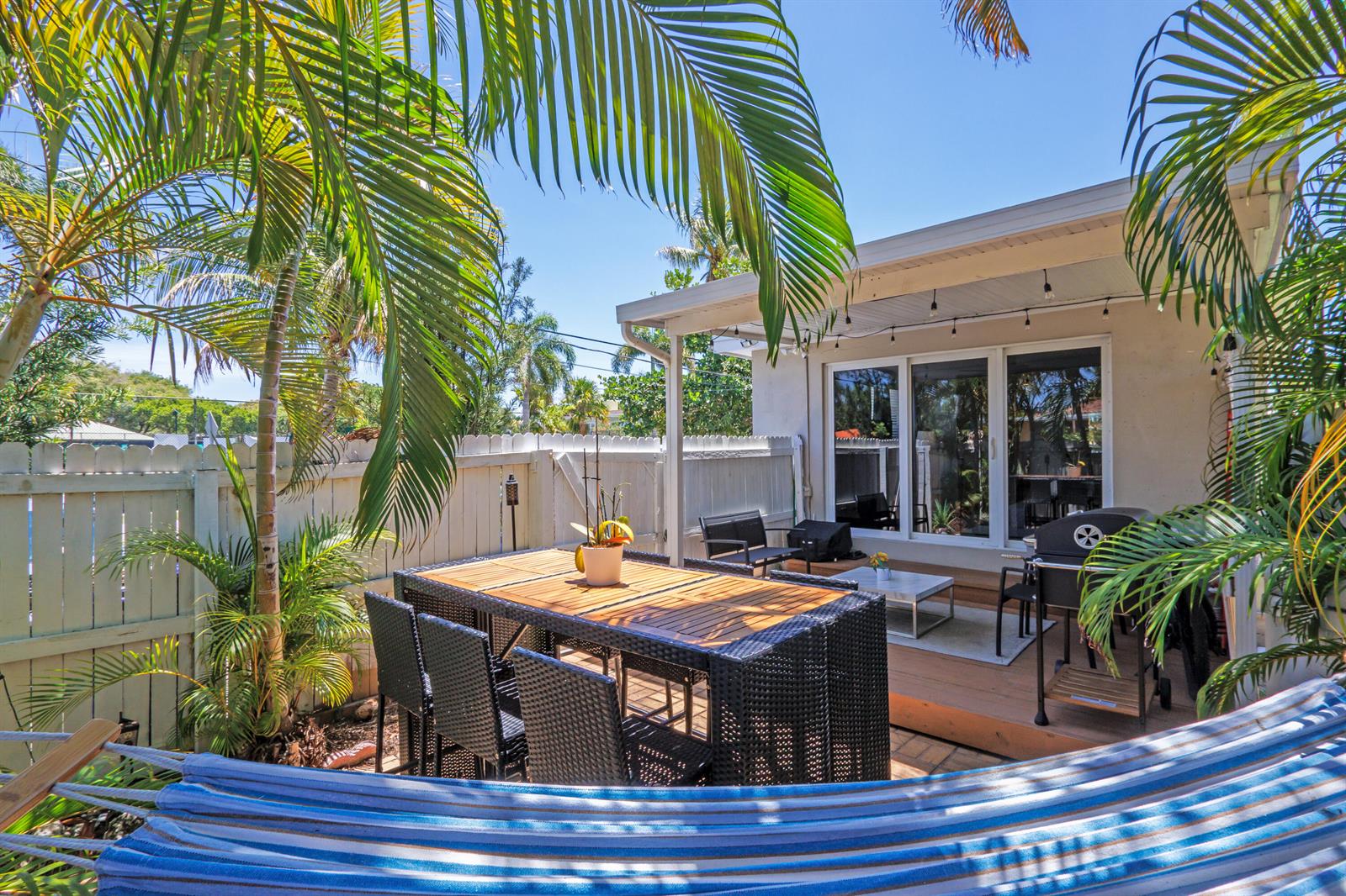 A living room features dark gray sofas, a central coffee table, and a large television — 1603 Jefferson Street, Hollywood FL 33020, HOLLYWOOD, FL