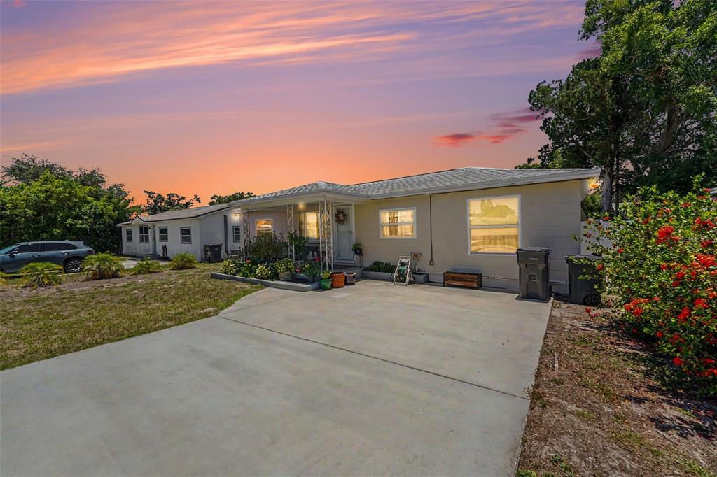 A single-story house with a concrete driveway and a sunset sky in the background — 4540 53RD AVENUE N, ST PETERSBURG, FL