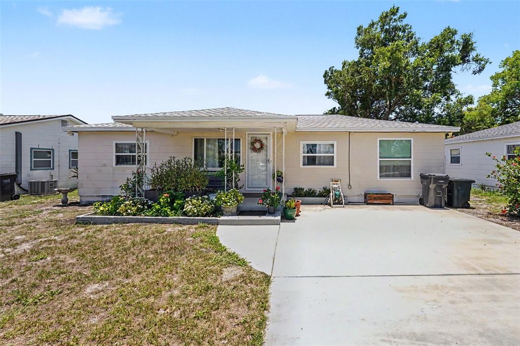 A single-story house with light siding, a concrete driveway, and a small front garden — 4540 53RD AVENUE N, ST PETERSBURG, FL