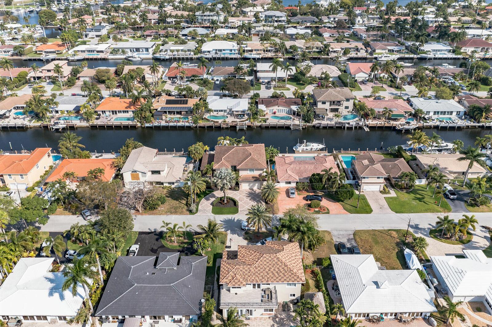 An aerial view shows waterfront houses with swimming pools, docks, and boats along a canal — 2461 SE 10th Street, Pompano Beach FL 33062, POMPANO BEACH, FL