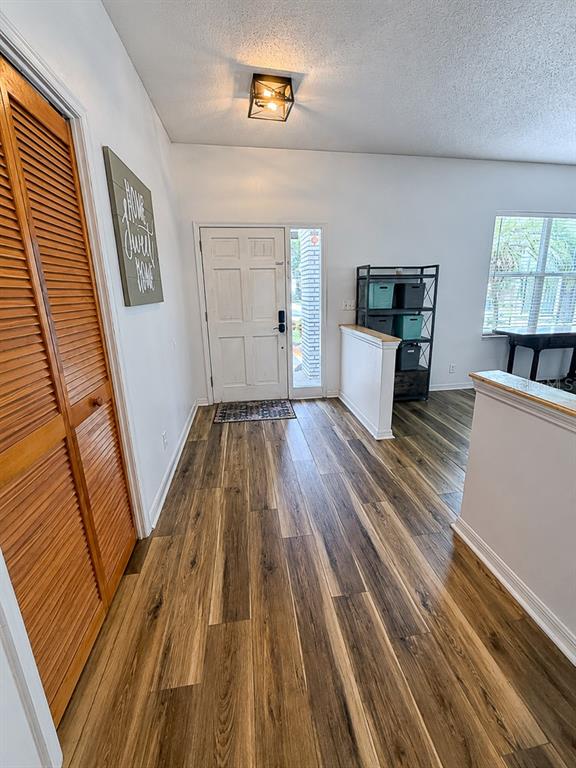 An entryway features wood-look flooring, a white front door, and a louvered closet door — 859 HARBOR HILL DRIVE, SAFETY HARBOR, FL