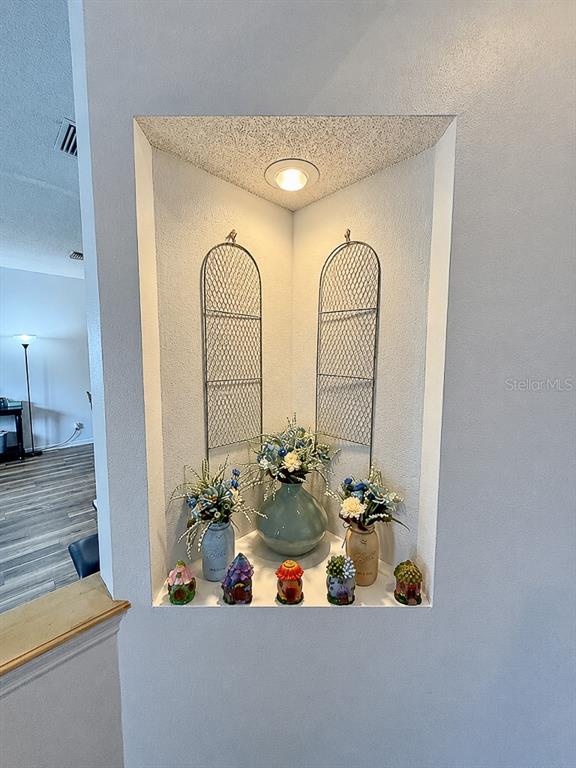 A recessed corner wall niche features decorative wire panels, floral arrangements, and small figurines — 859 HARBOR HILL DRIVE, SAFETY HARBOR, FL