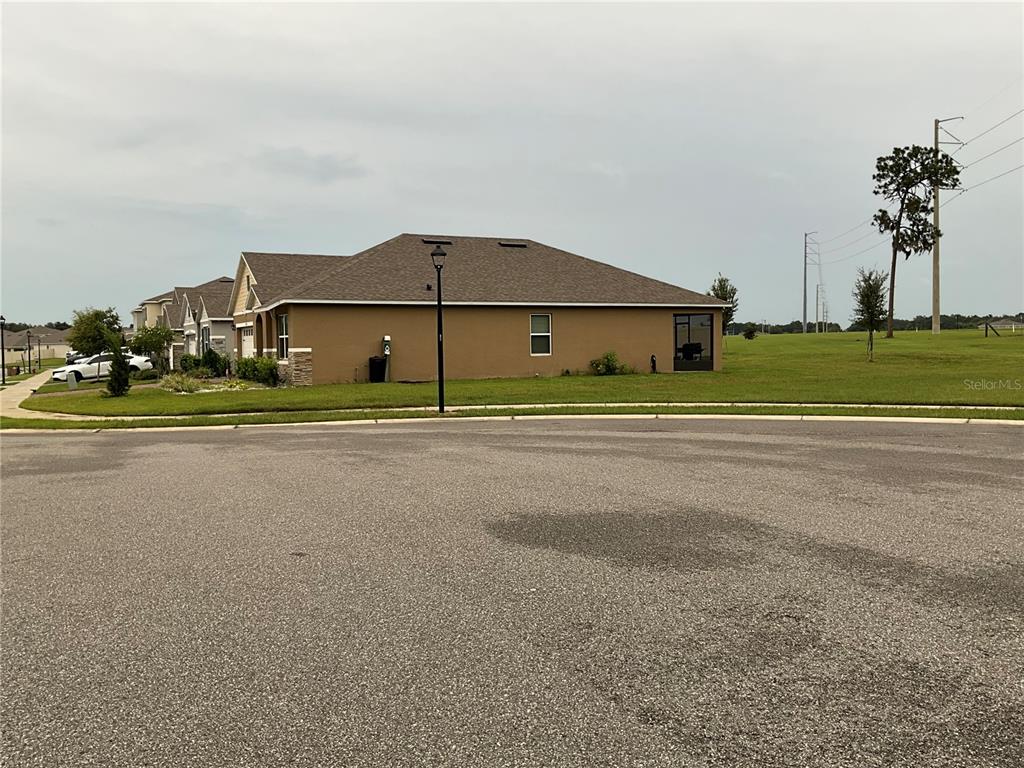 A tan single-story house with a brown roof sits on a corner lot — 33525 ALWAYS DREAMING COURT, SORRENTO, FL