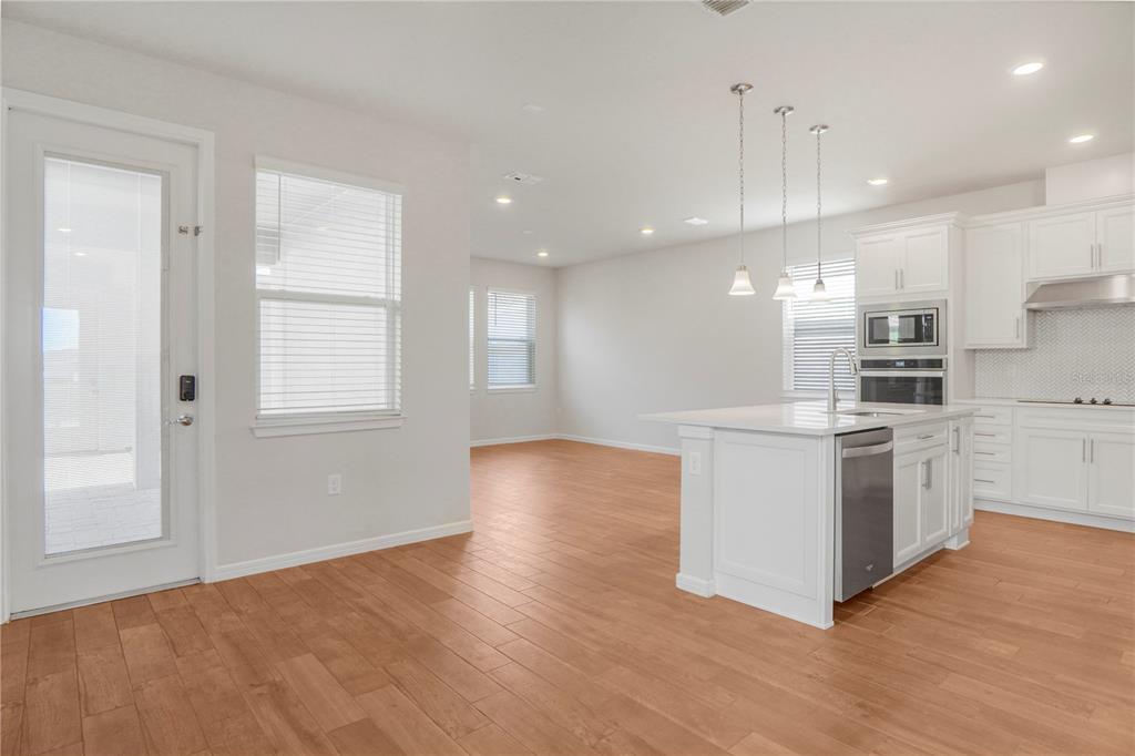 A bright kitchen with white cabinets, a center island, and wood-look tile flooring — 14025 KAUAI DRIVE, ORLANDO, FL