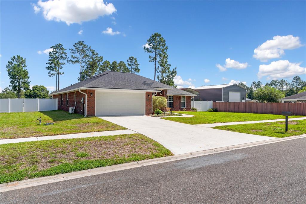 A single-story brick house with a two-car garage and a concrete driveway — 4415 TALL PINES LANE, MIDDLEBURG, FL