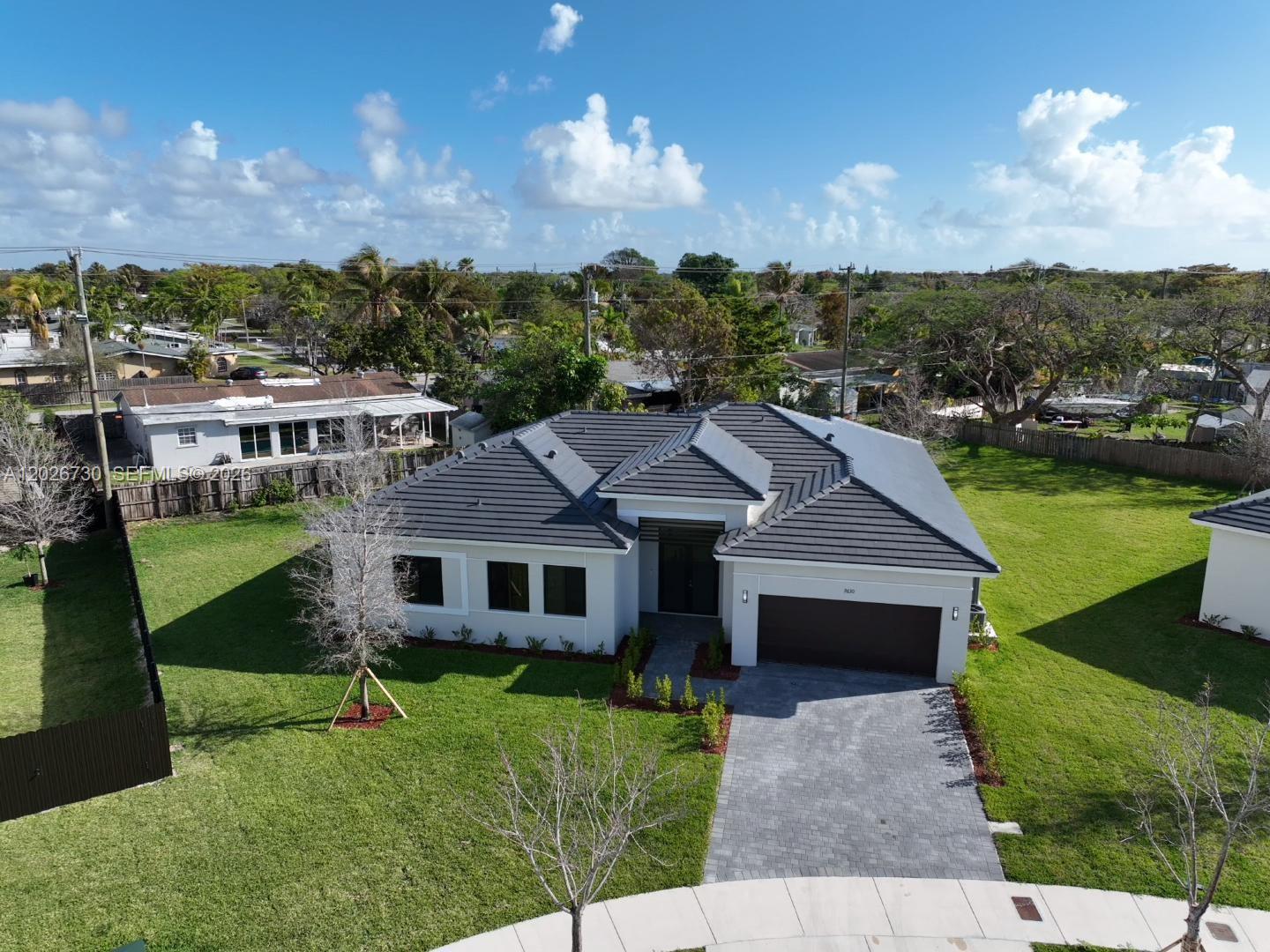 An aerial view of a single-story house with a dark tiled roof and driveway — 9630 SW 208th Ter, Cutler Bay FL 33189, CUTLER BAY, FL
