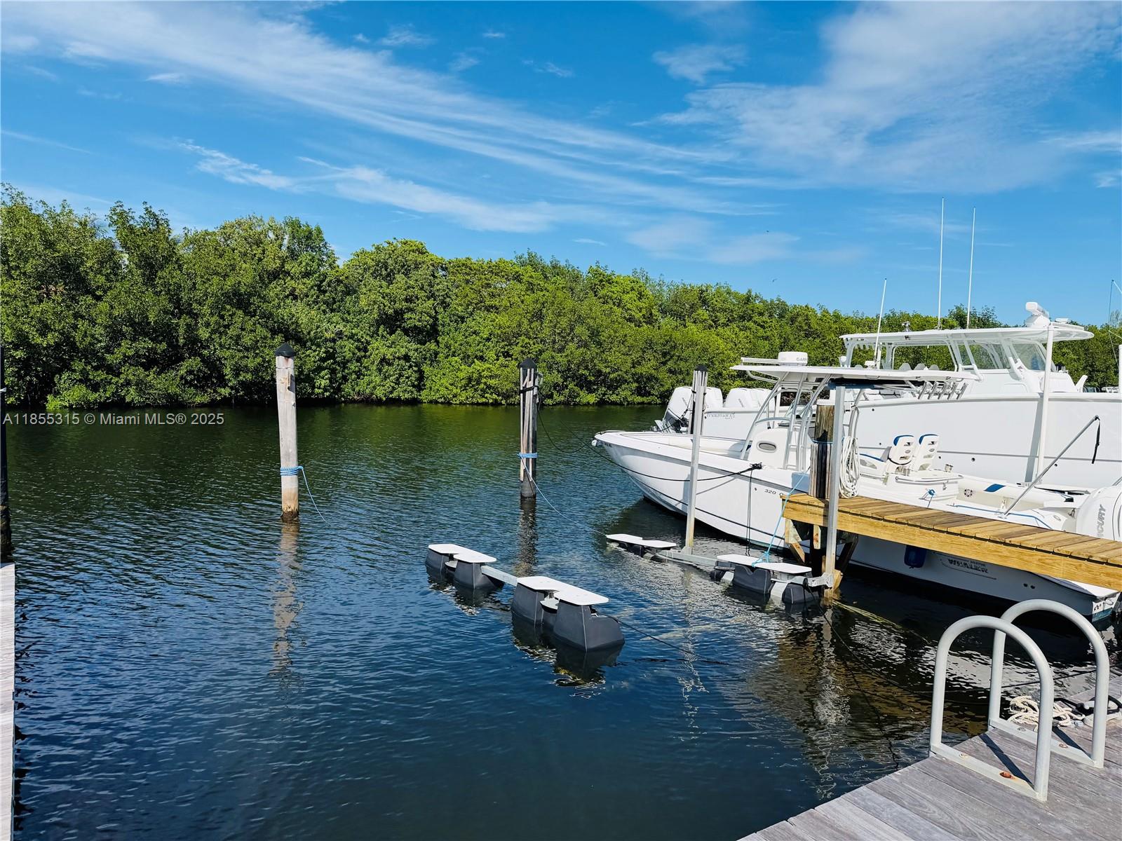 A white boat is docked at a wooden pier next to a dense mangrove forest — 6200 SW 152nd St #5, Palmetto Bay FL 33157, PALMETTO BAY, FL