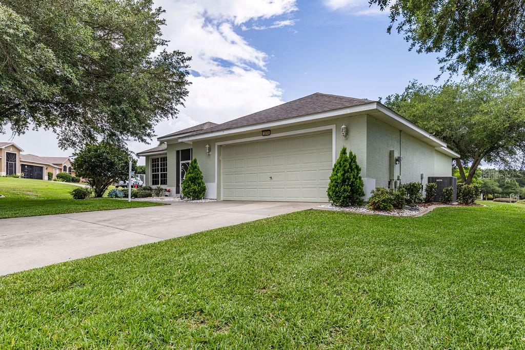 A light green single-story house with a two-car garage and a concrete driveway — 3370 SAINT LUCIA COURT, TAVARES, FL