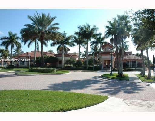 A paved driveway leads to a large clubhouse surrounded by numerous tall palm trees — 18741 SW 25th Ct, Miramar FL 33029, MIRAMAR, FL
