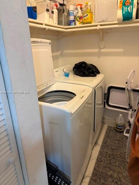 A laundry closet contains a white top-loading washing machine and shelves stocked with cleaning supplies — MIAMI, FL