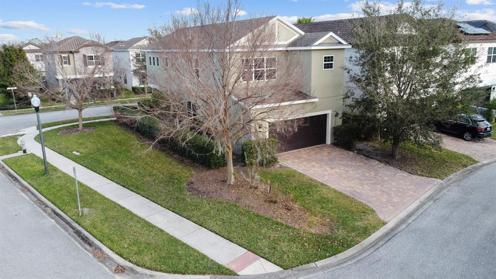 An aerial view of a two-story house with a paved driveway and a corner lawn — 9306 MIRA VALLE LANE, WINTER GARDEN, FL