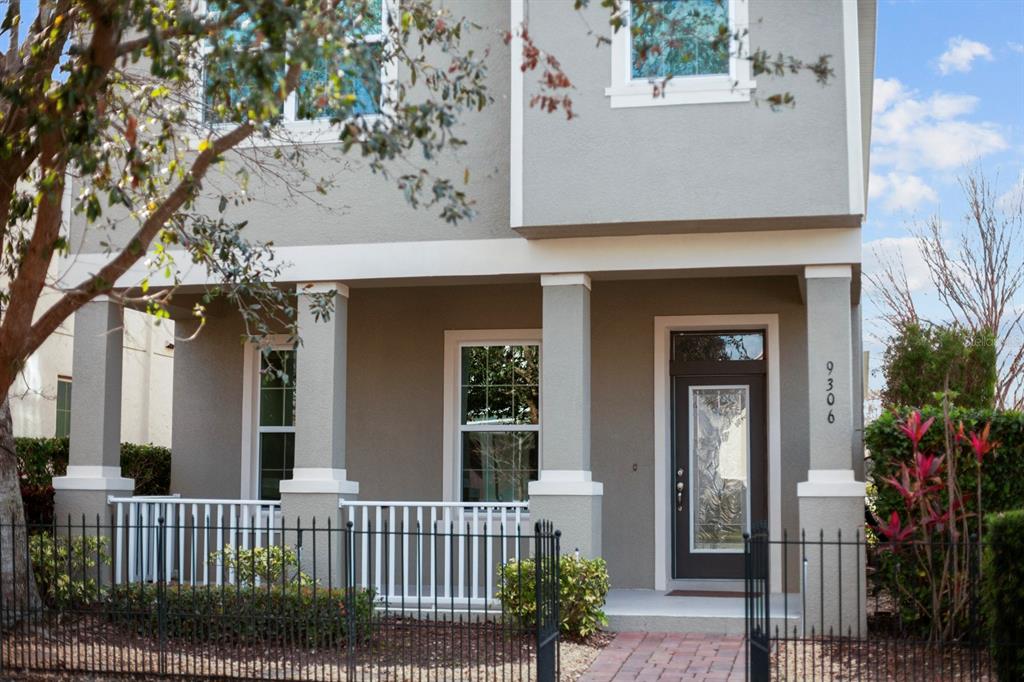 A two-story house with a covered front porch, white railings, and a dark front door — 9306 MIRA VALLE LANE, WINTER GARDEN, FL