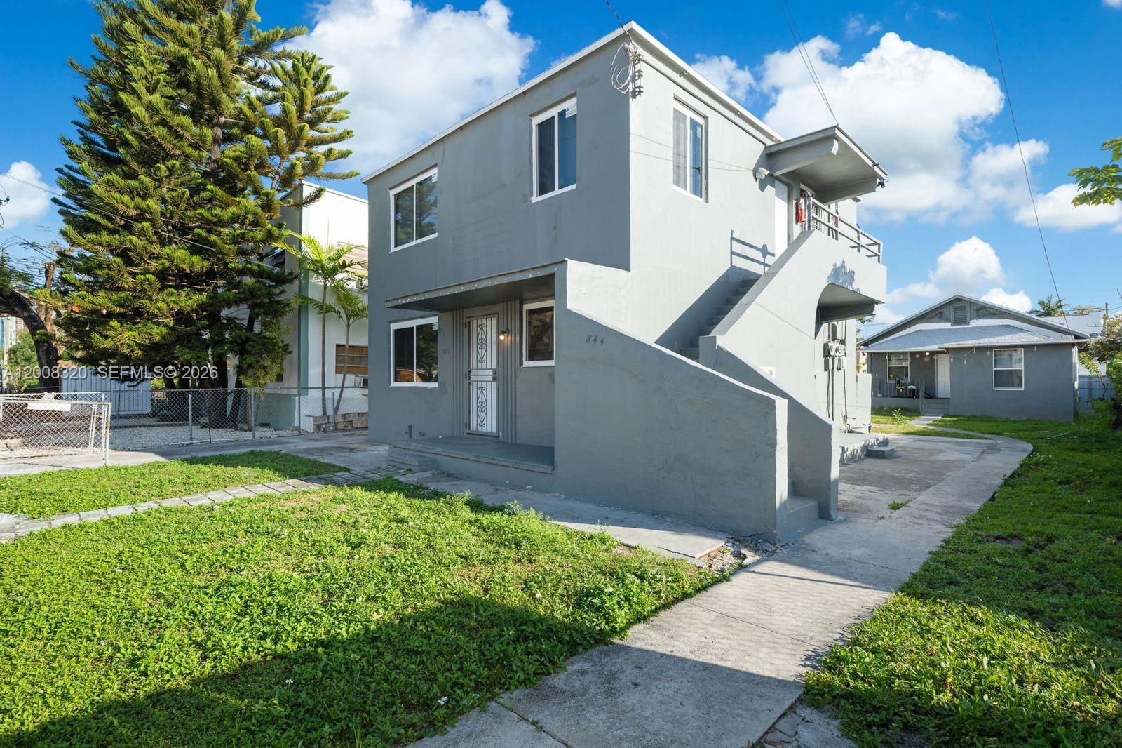 A two-story gray stucco building features an exterior staircase and a concrete walkway — 842 SW 3rd St, Miami FL 33130, MIAMI, FL
