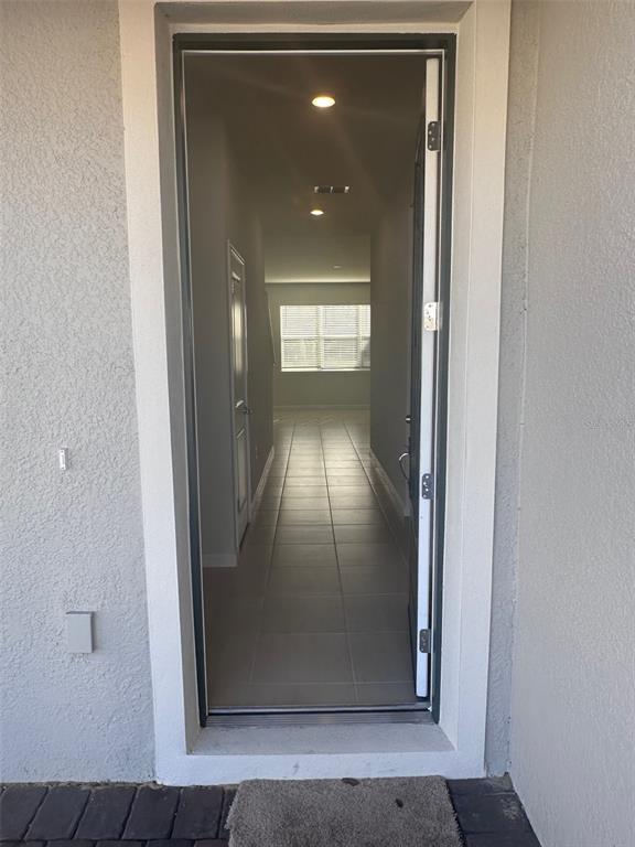 An open front door reveals a tiled entryway leading to a hallway with recessed lighting — 17539 SAW PALMETTO AVENUE, CLERMONT, FL