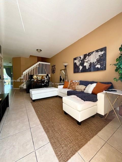 A living room features a beige sofa, a white ottoman, and a world map wall art — 641 NE 21st Ter, Homestead FL 33033, HOMESTEAD, FL