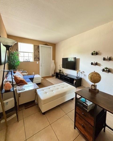 A living room features a white ottoman, a sofa, a television, and a wooden desk — 641 NE 21st Ter, Homestead FL 33033, HOMESTEAD, FL