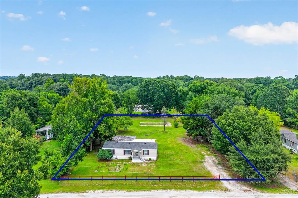 An aerial view shows a single-story house situated on a grassy lot with surrounding trees — 2535 SE 172ND STREET, SUMMERFIELD, FL
