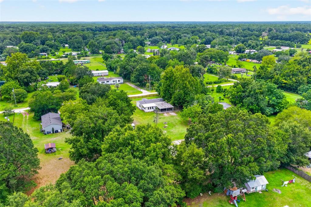 An aerial view shows several houses scattered across a large, tree-filled rural property — 2535 SE 172ND STREET, SUMMERFIELD, FL