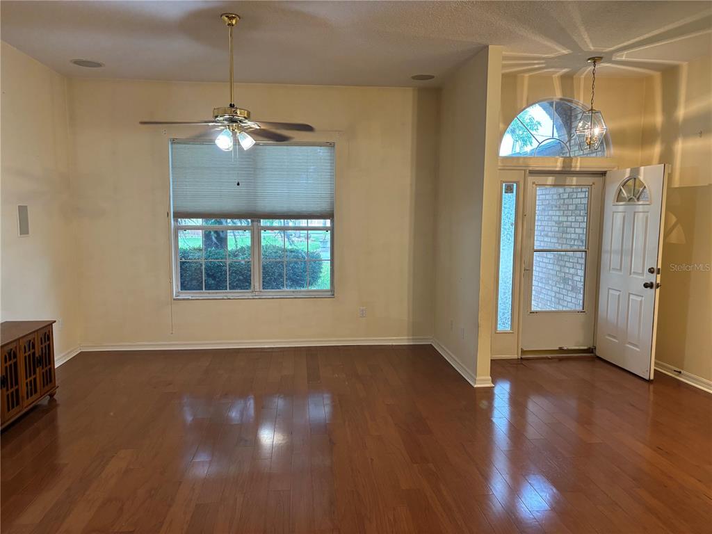 A living room features hardwood floors, a ceiling fan, and a front entryway with glass — 5 BIRD HAVEN PLACE, PALM COAST, FL