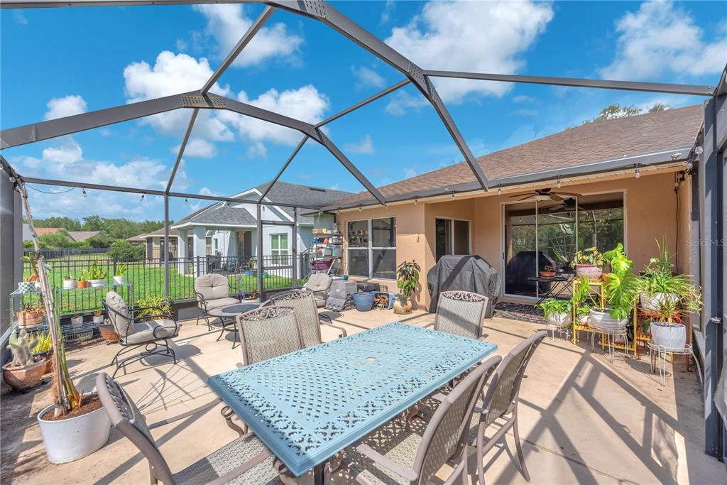 A single-story suburban house with a beige exterior, a two-car garage, and a teal front door — 16316 BRIDGEGLADE LANE, LITHIA, FL
