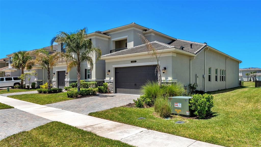 A two-story suburban house features a paved driveway, a garage, and a green lawn — 3405 JUNIPER SPRINGS STREET, WESLEY CHAPEL, FL