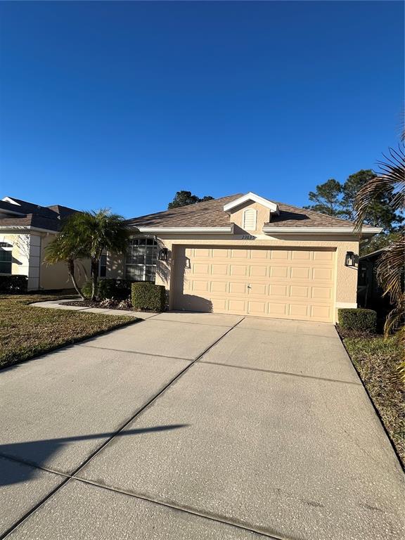 A living room with a brown sofa, coffee table, and a window with blinds — 23835 CORAL RIDGE LANE, LAND O LAKES, FL