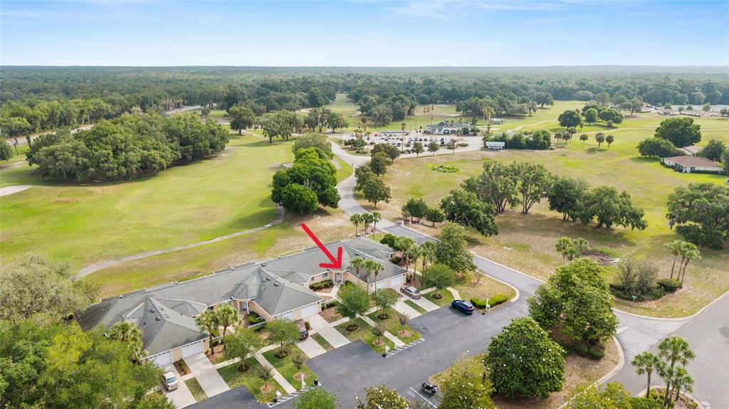 An aerial view shows a single-story multi-unit residential building with a red arrow pointing toward an entrance — 13640 SW 115TH AVENUE, DUNNELLON, FL