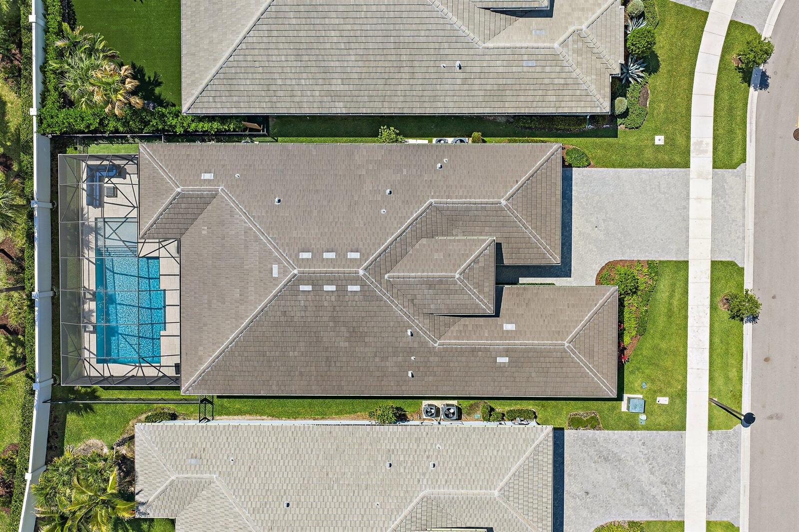 An aerial view shows a house with a tiled roof, a screened-in pool, and driveway — 12172 Waterstone Circle, Palm Beach Gardens FL 33412, PALM BEACH GARDENS, FL