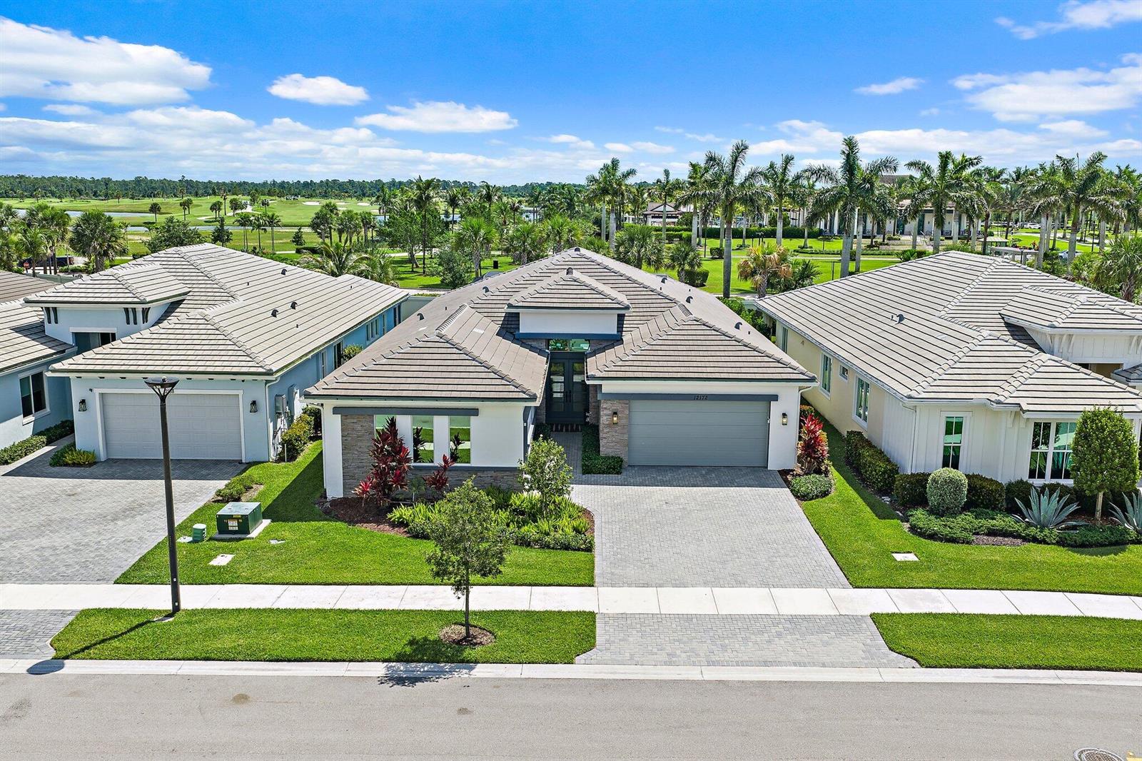 An aerial view shows a modern single-story house with a gray tile roof and driveway — 12172 Waterstone Circle, Palm Beach Gardens FL 33412, PALM BEACH GARDENS, FL