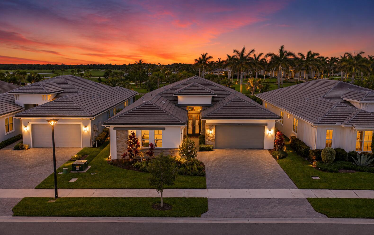 An aerial view of three suburban houses with tiled roofs at sunset — 12172 Waterstone Circle, Palm Beach Gardens FL 33412, PALM BEACH GARDENS, FL