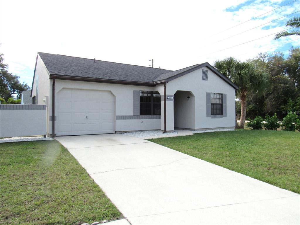 A single-story house with a light-colored exterior, a one-car garage, and a concrete driveway — 20005 GOLDCUP COURT, PORT CHARLOTTE, FL