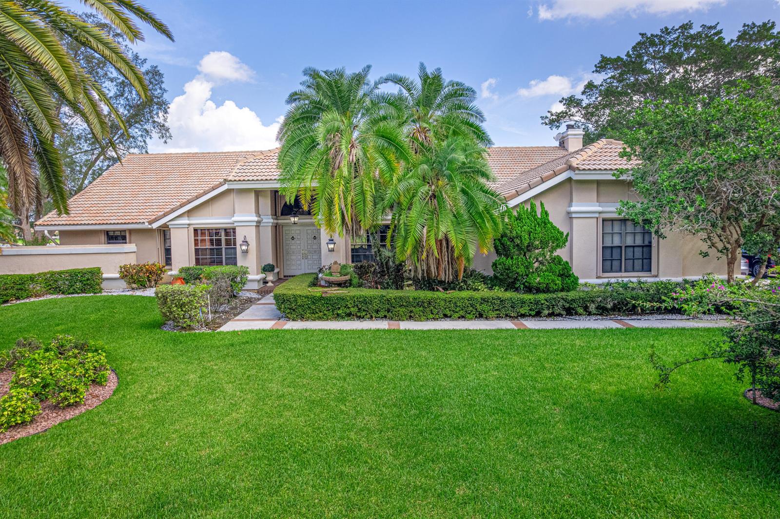 A single-story house with a tiled roof, palm trees, and a manicured lawn — 7511 Brigantine Lane, Parkland FL 33067, PARKLAND, FL