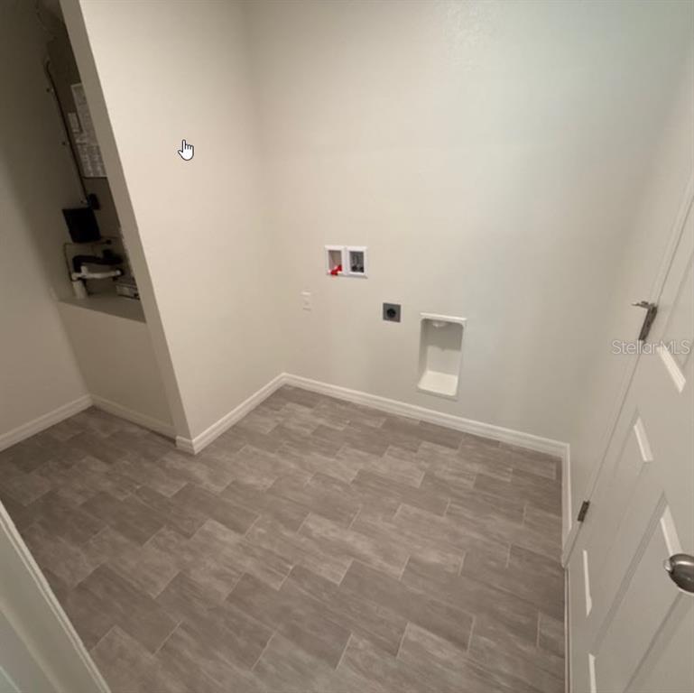 A laundry room features gray wood-look tile flooring and connections for a washer and dryer — 37 PACKARD LANE, PALM COAST, FL