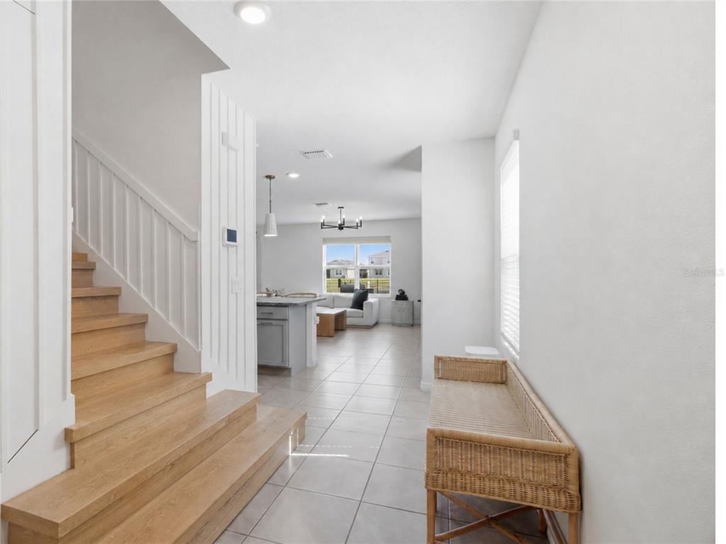 A view from a hallway toward an open-concept kitchen and living area with tiled floors — 3262 HILLTOP CIRCLE, BRADENTON, FL