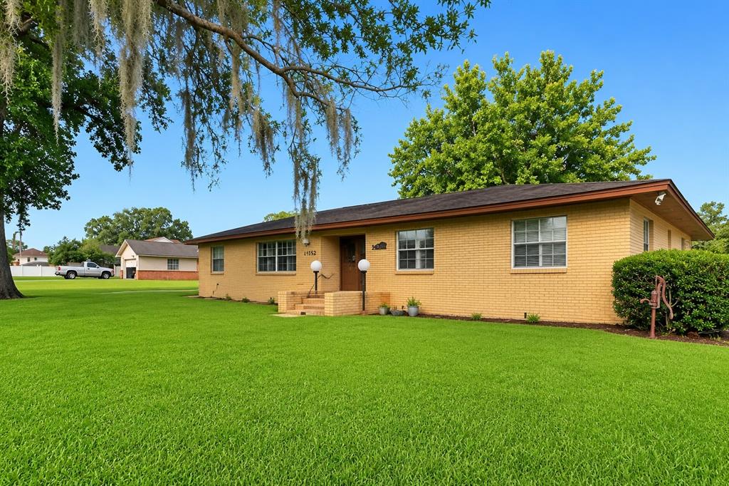 A single-story white brick house features a wooden porch gable and black window shutters — 1452 DINGENS AVENUE, WINDERMERE, FL