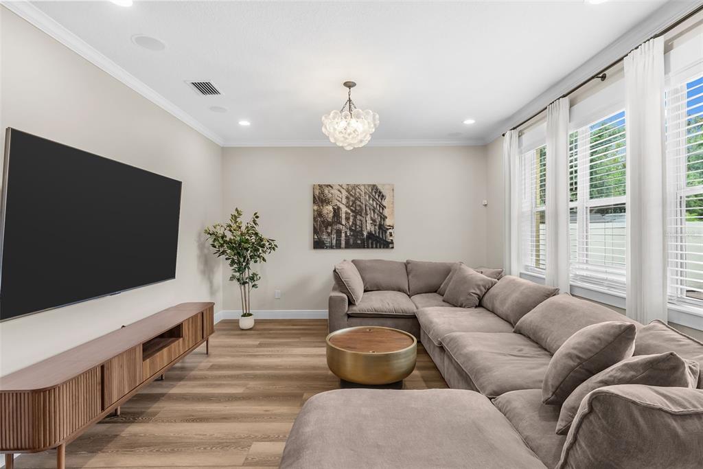 A living room features a large sectional sofa, a wooden media console, and a coffee table — 2915 W BAY VIEW AVENUE, TAMPA, FL