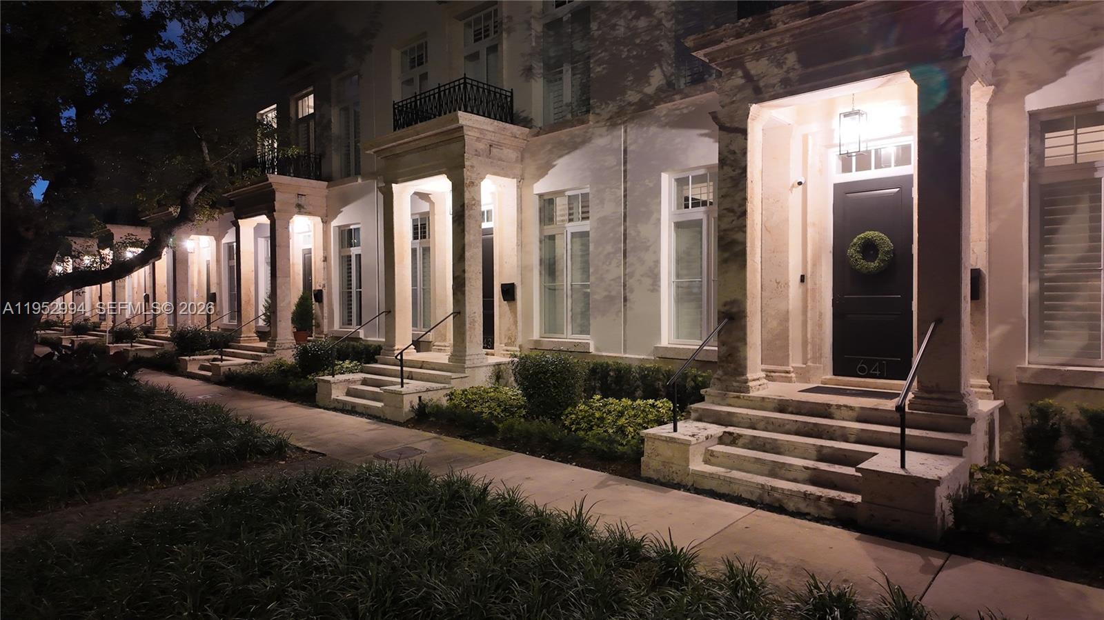 A row of townhouses with stone entryways and black doors at night — 641 Almeria Ave, Coral Gables FL 33134, CORAL GABLES, FL