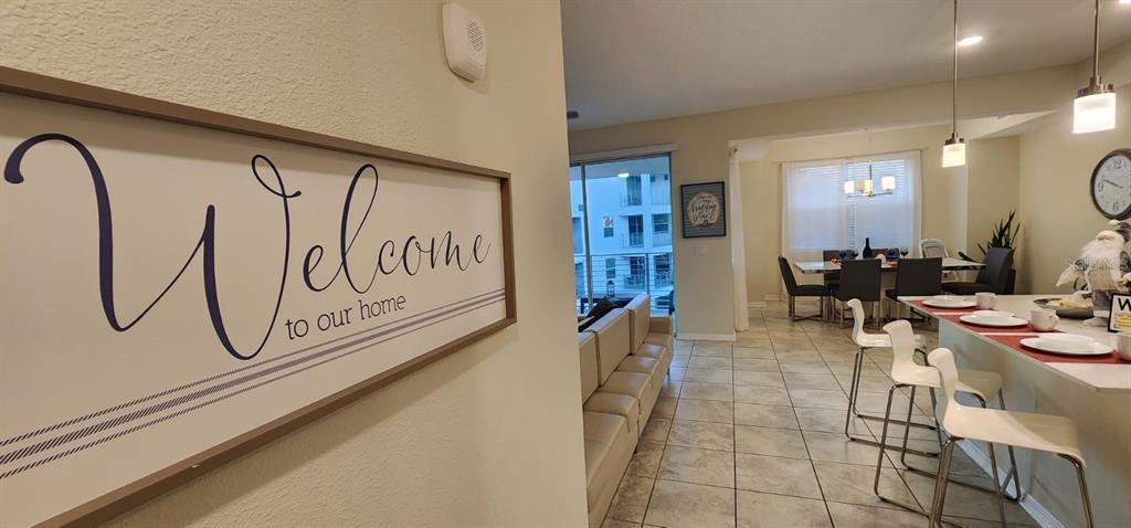 A view from an entryway into a living and dining area with tile flooring — 3150 PARADOX CIRCLE UNIT 302, KISSIMMEE, FL