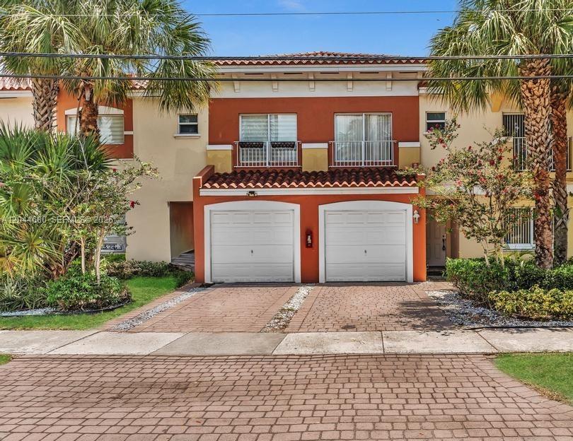 A two-story townhouse exterior features a two-car garage, balconies, and palm trees — 1316 NW 3rd St, Fort Lauderdale FL 33311, FORT LAUDERDALE, FL