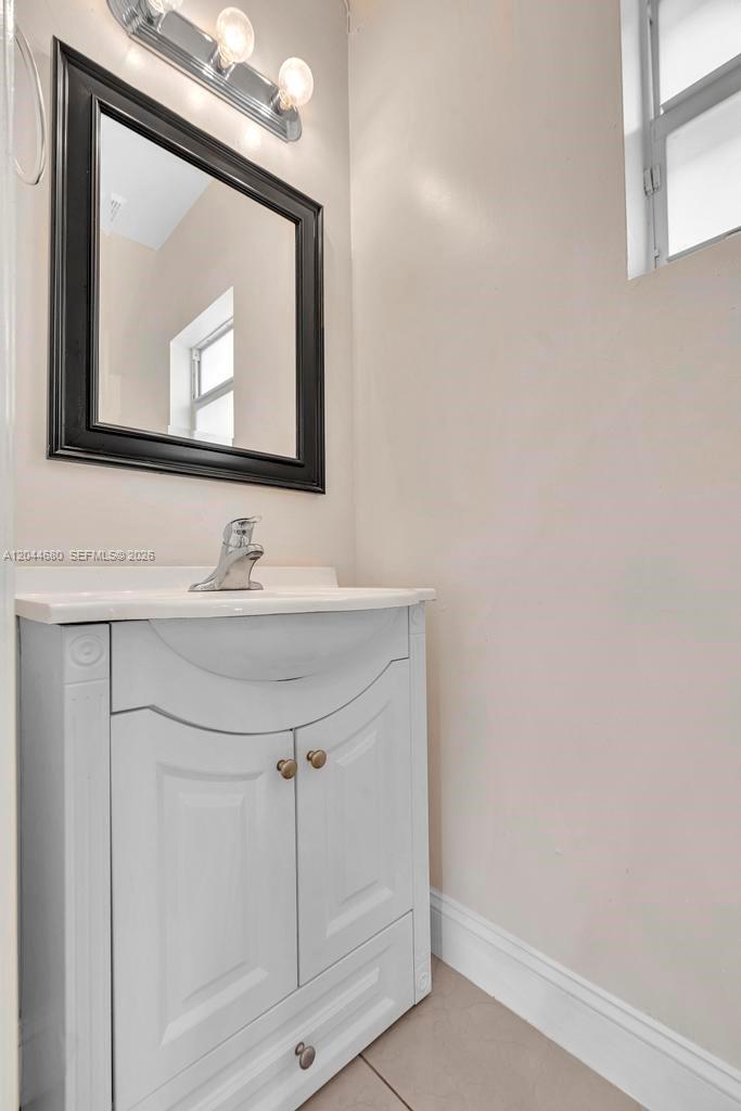 A bathroom features a white vanity, a silver faucet, and a black-framed mirror — 1316 NW 3rd St, Fort Lauderdale FL 33311, FORT LAUDERDALE, FL