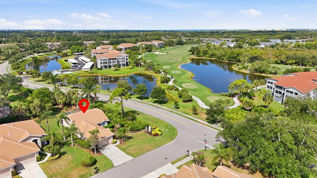 An aerial view shows a residential house with a red pin, surrounded by golf course greenery — 9402 FOREST HILLS CIRCLE, SARASOTA, FL