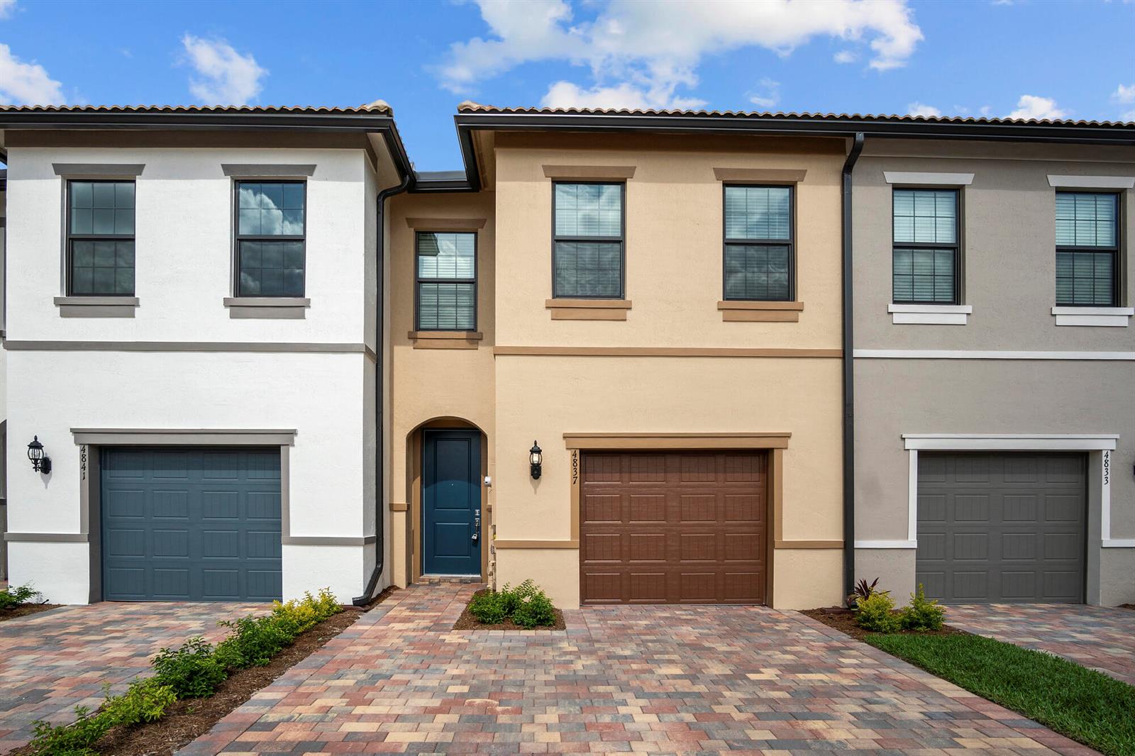 A row of three attached townhomes with paved driveways, garages, and stucco exteriors — 4837 Chantilly Road, Lake Worth FL 33467, LAKE WORTH, FL