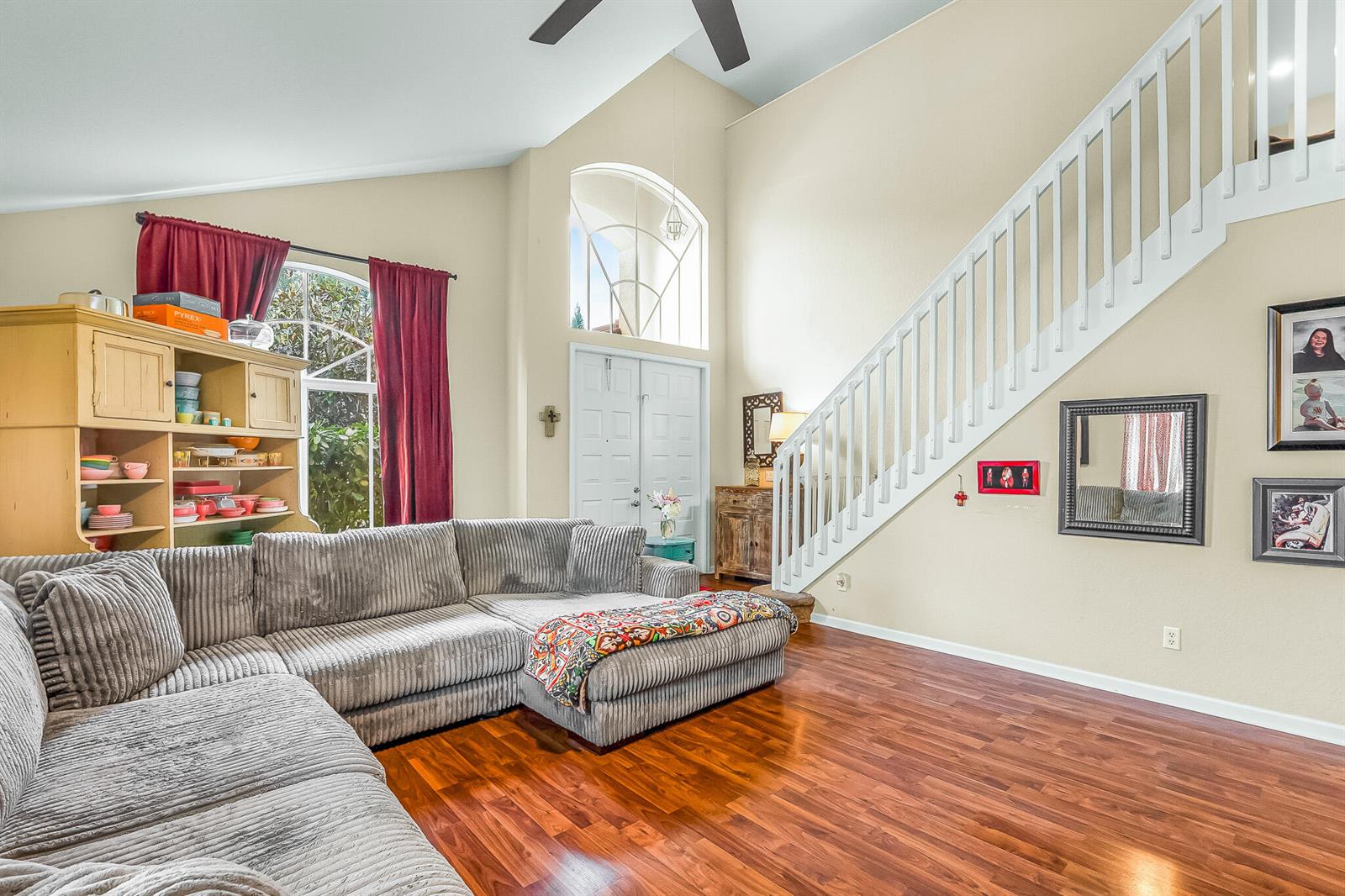 A living room features a sectional sofa, hardwood floors, a staircase, and a vaulted ceiling — 9262 Silver Glen Way, Lake Worth FL 33467, LAKE WORTH, FL