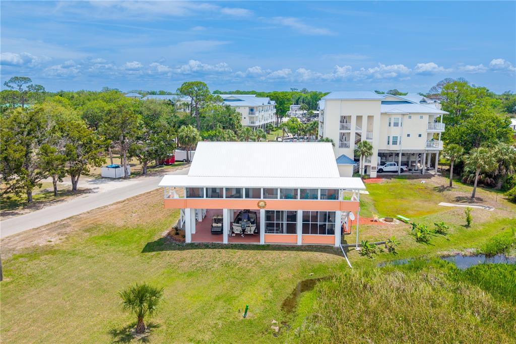 An aerial view of a stilted house with a screened porch and a metal roof — 200/202 NE 205TH STREET, SUWANNEE, FL