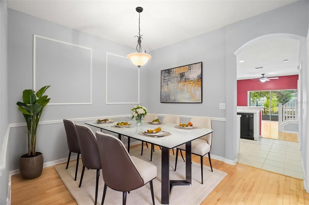 A dining room features a glass-topped table, six chairs, and light gray walls with molding — 13137 KINGS CROSSING DRIVE, GIBSONTON, FL