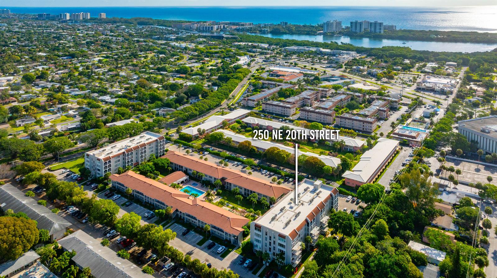 An aerial view shows a multi-story apartment complex with a pool and surrounding residential neighborhood — 250 NE 20th Street # 5260, Boca Raton FL 33431, BOCA RATON, FL