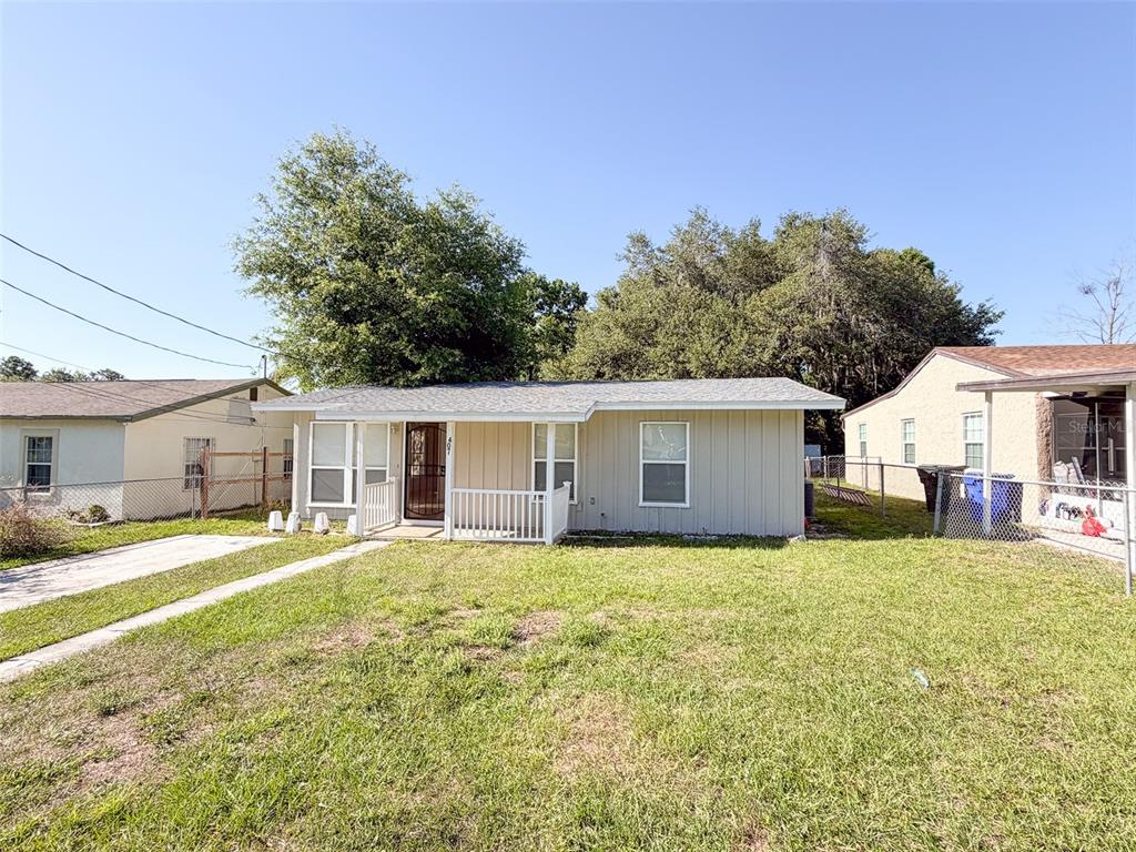 A single-story house with light-colored siding, a front porch, and a grassy yard — 407 W BELLA VISTA STREET, LAKELAND, FL