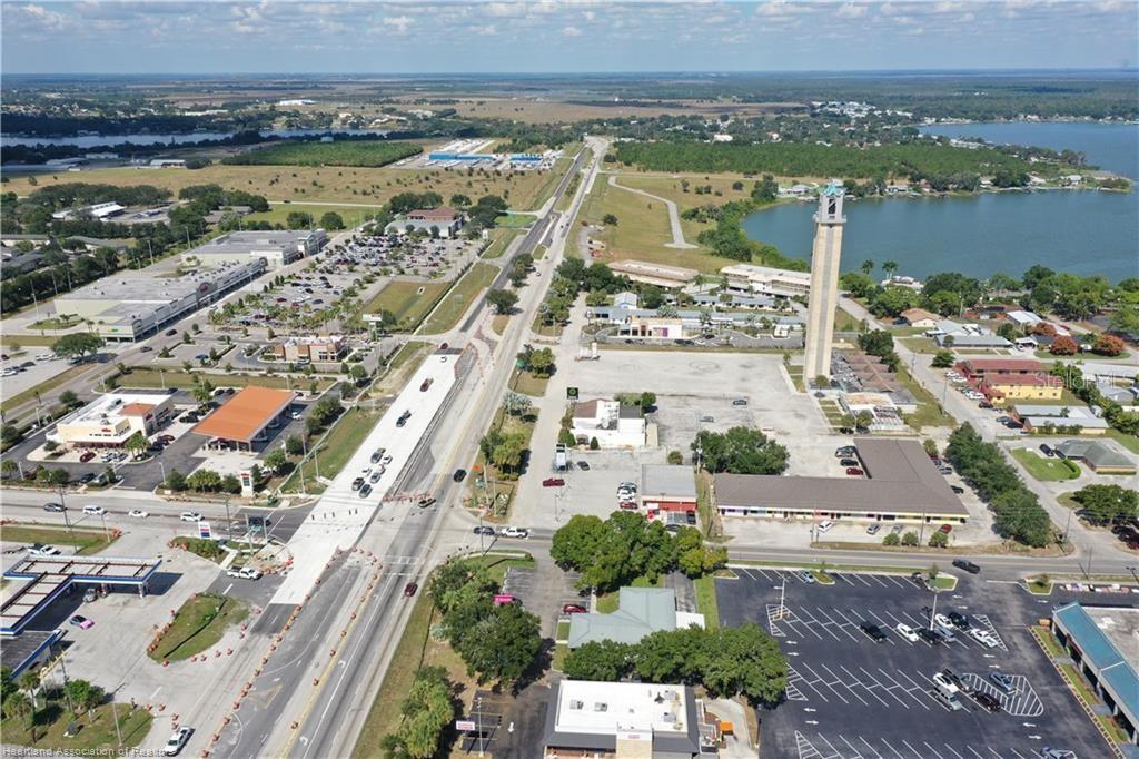 An aerial view shows a commercial area with a tall tower, parking lots, and roads — 419 US 27 N, LAKE PLACID, FL