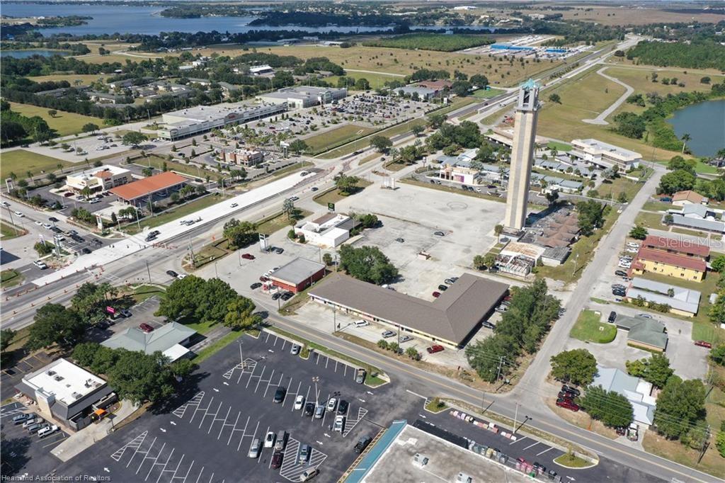 An aerial view shows a commercial area with a tall tower and surrounding parking lots — 419 US 27 N, LAKE PLACID, FL