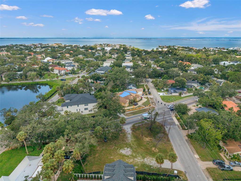 An aerial view shows a residential neighborhood with houses, a small lake, and a coastal bay — 2504 S WEST SHORE BOULEVARD, TAMPA, FL